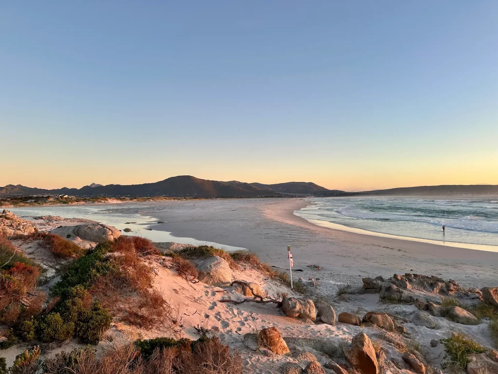 Sonnenuntergang am Strand in Noordhoek in der Nähe von Kapstadt und dem Chapmans Peak Drive in Sueadafrika.